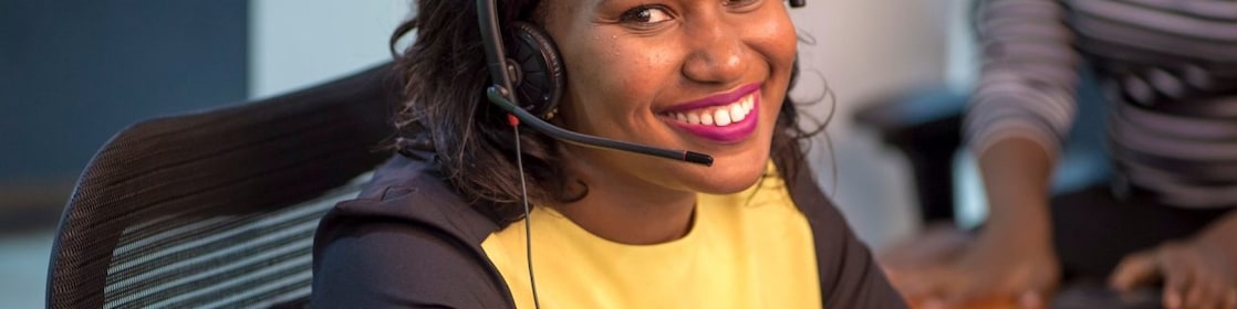 Collaboratrice souriante au téléphone avec un client