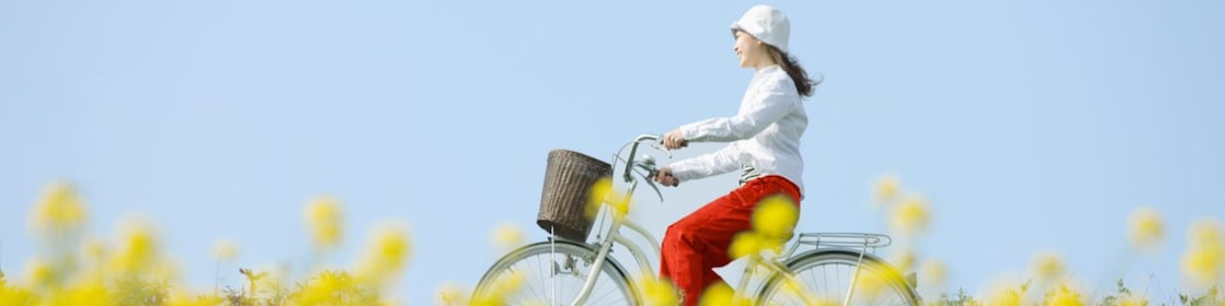 Une jeune femme fait une promenade à vélo dans un champ en été