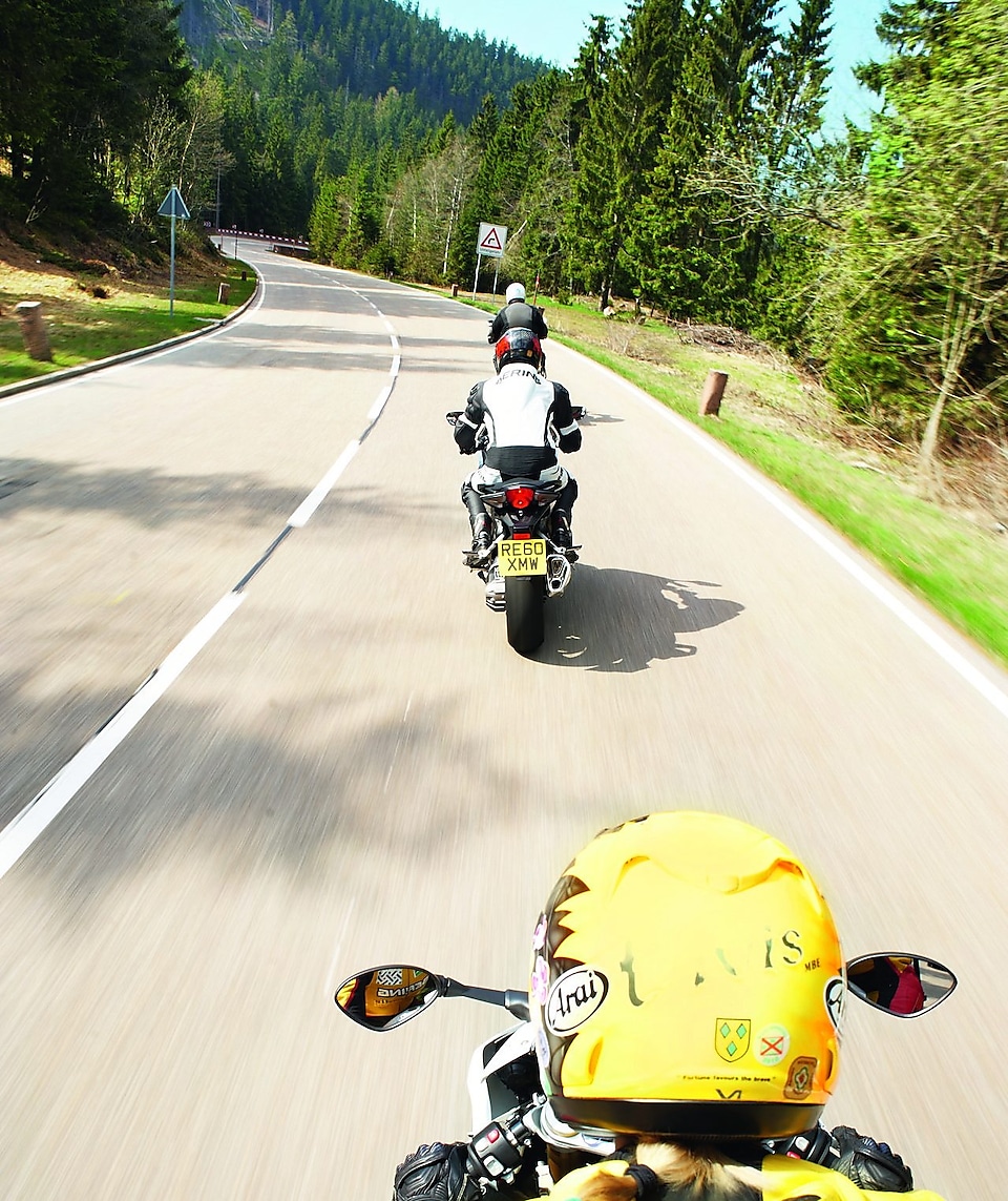 Trois motos qui roulent sur une route de montagne