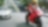 Moto rouge et conducteur sur une route avec des voitures et des bâtiments dans l’arrière-plan.